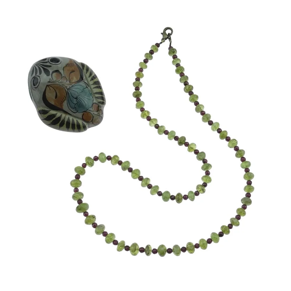Un collier légèrement long avec des perles vertes et un crâne.