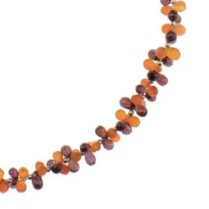Un collier fait de cornaline et grenat en briolette avec des apprêts en argent avec des perles de cornaline orange.